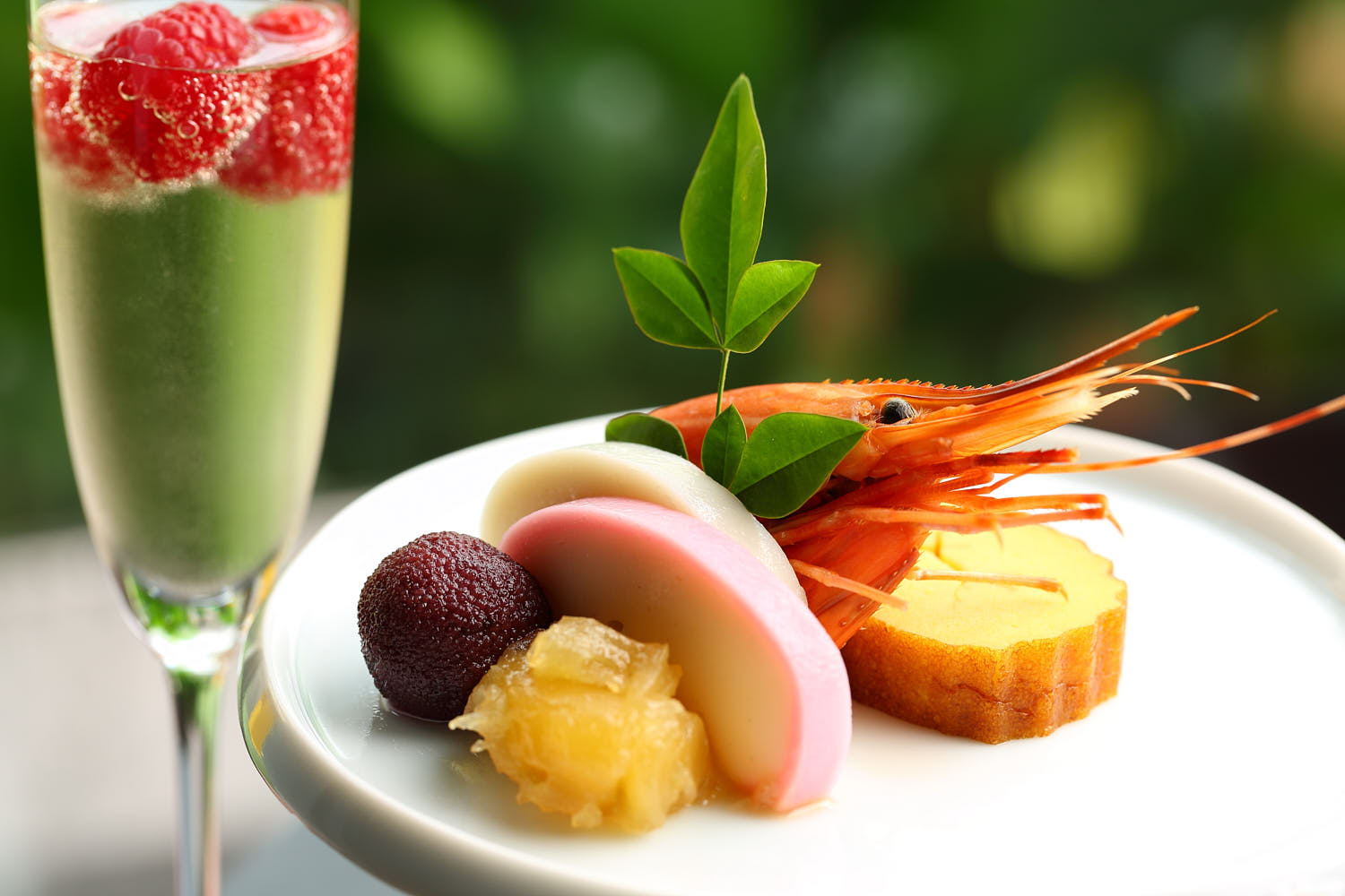 Champagne with raspberries, served alongside prawns with Japanese-inspired garnishes.
