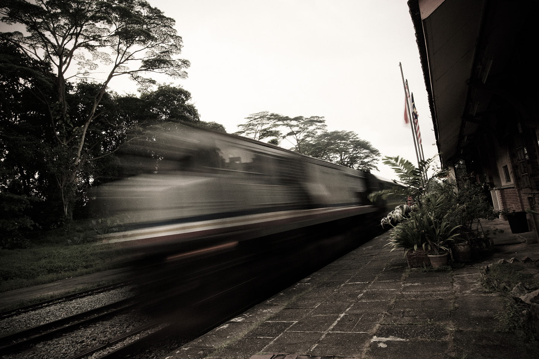 Fine art photo of a KTM train in motion blur passing Bukit Timah Railway Station, Singapore.