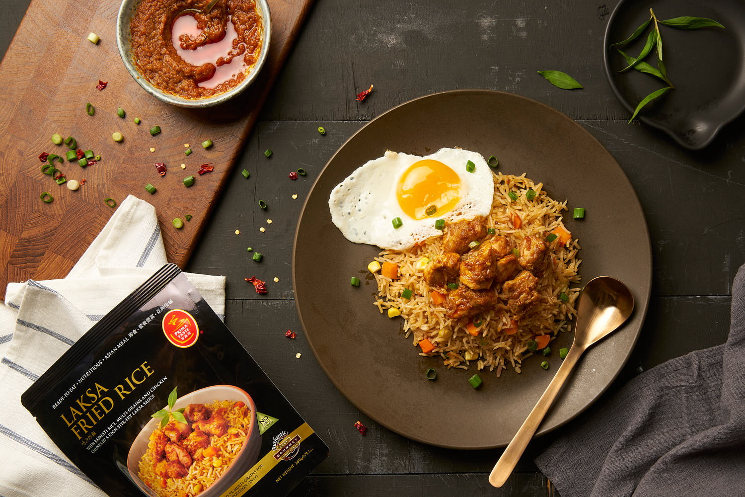 Top down shot of Prima Laksa Fried Rice accompanied by sunny side up egg on a plate.