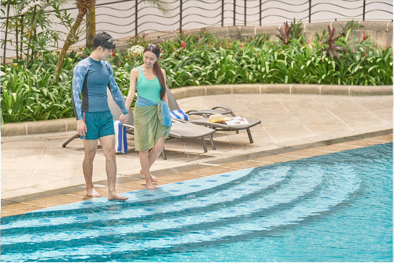 Couple enjoying a serene and luxurious experience while relaxing in an infinity pool at a resort.