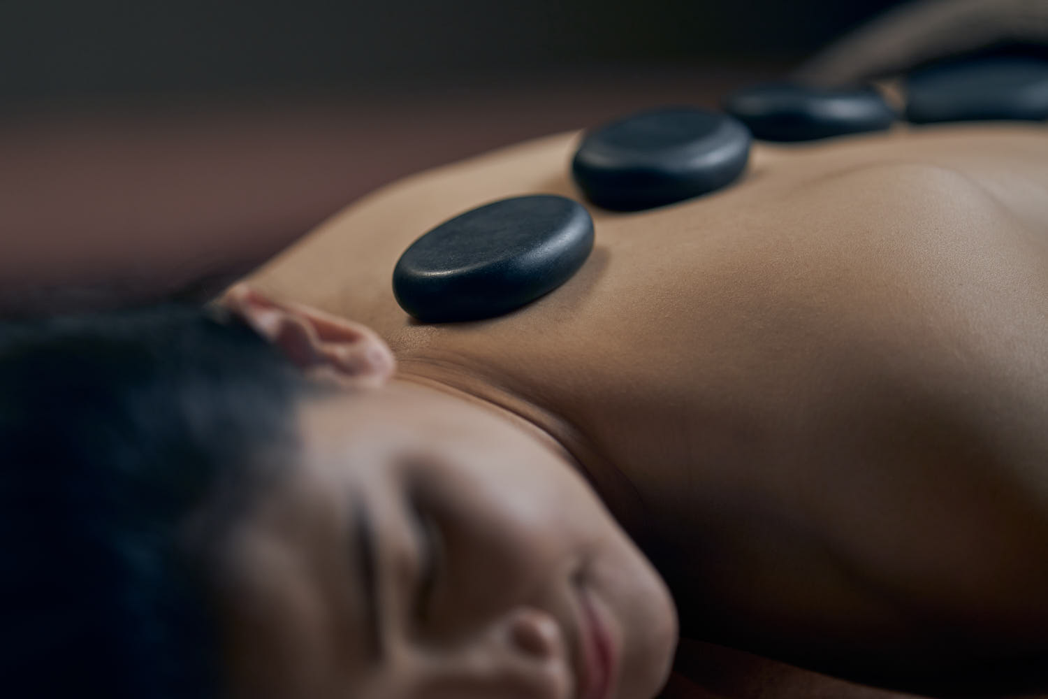 Guest experiencing a soothing hot stone massage at a luxury spa resort for ultimate relaxation.