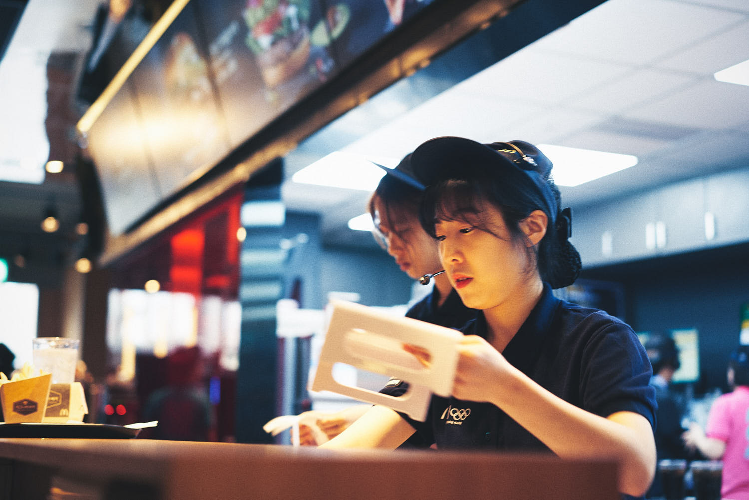 McDonald's server efficiently taking orders and serving customers at the fast-food restaurant.