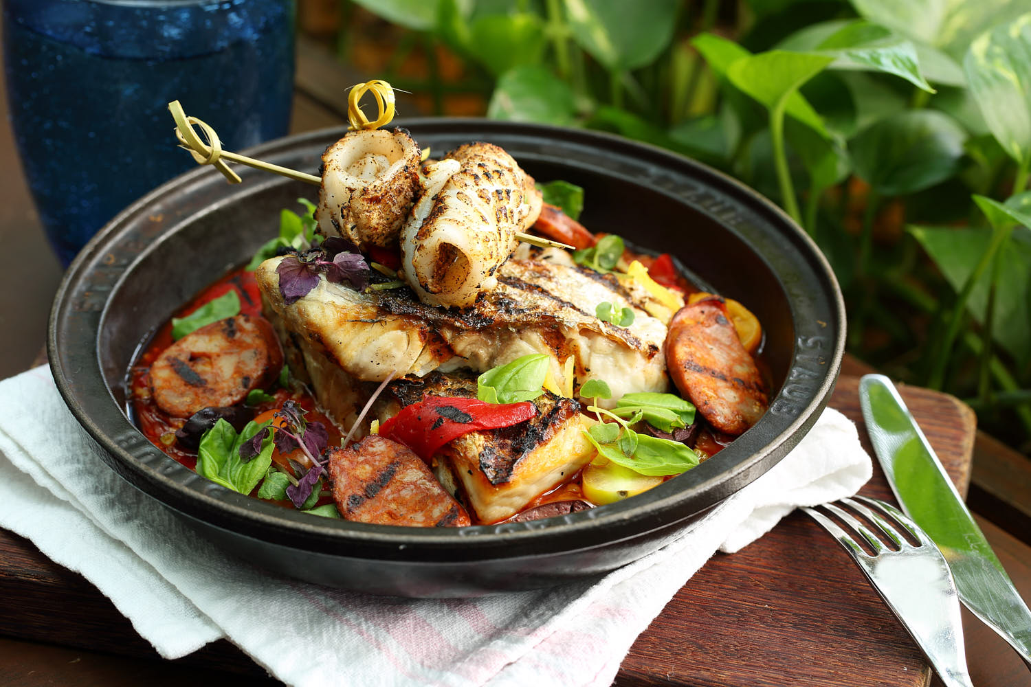 Vibrant Mediterranean seafood paella with fish, calamari, sausage and saffron rice.