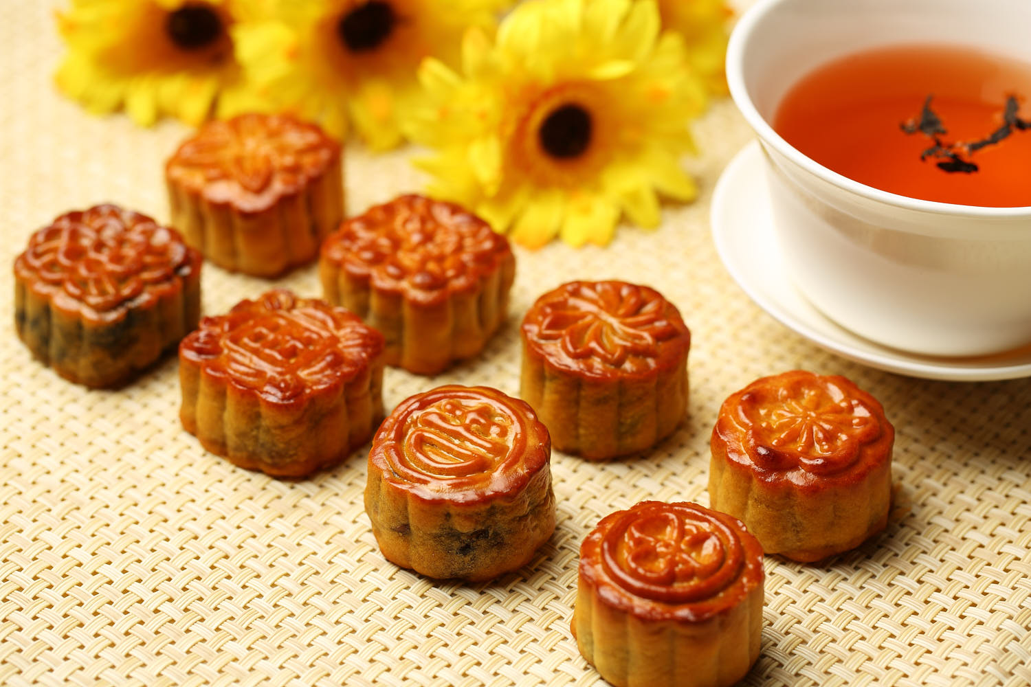 Elegant mooncake presented with subtle lighting, highlighting its texture served with tea.