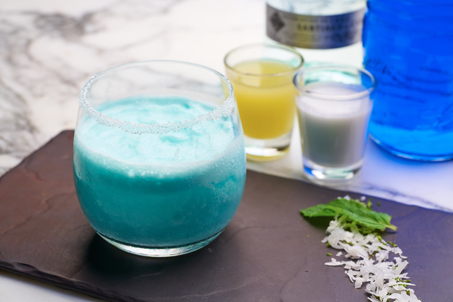 Close-up of a bright blue artisan beverage with garnish, styled at Pan Pacific Hotel.