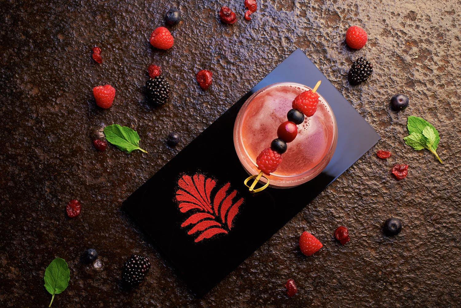 Top view of a colorful Pan Pacific Hotel cocktail with fresh fruit and herbs.
