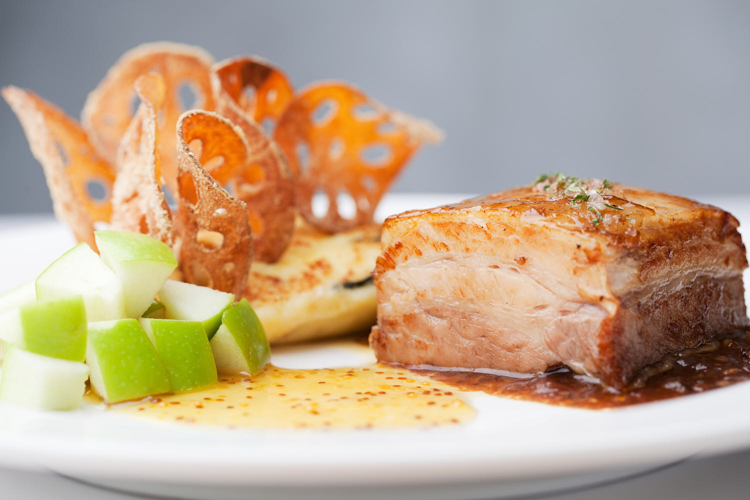 Close-up of juicy pork paired with apple cubes and herbs.