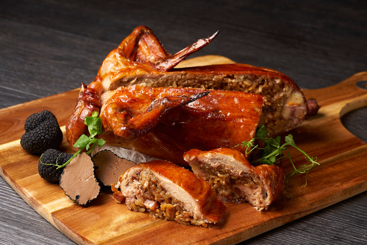 Close-up of roast chicken filled with aromatic truffle rice, garnished elegantly.