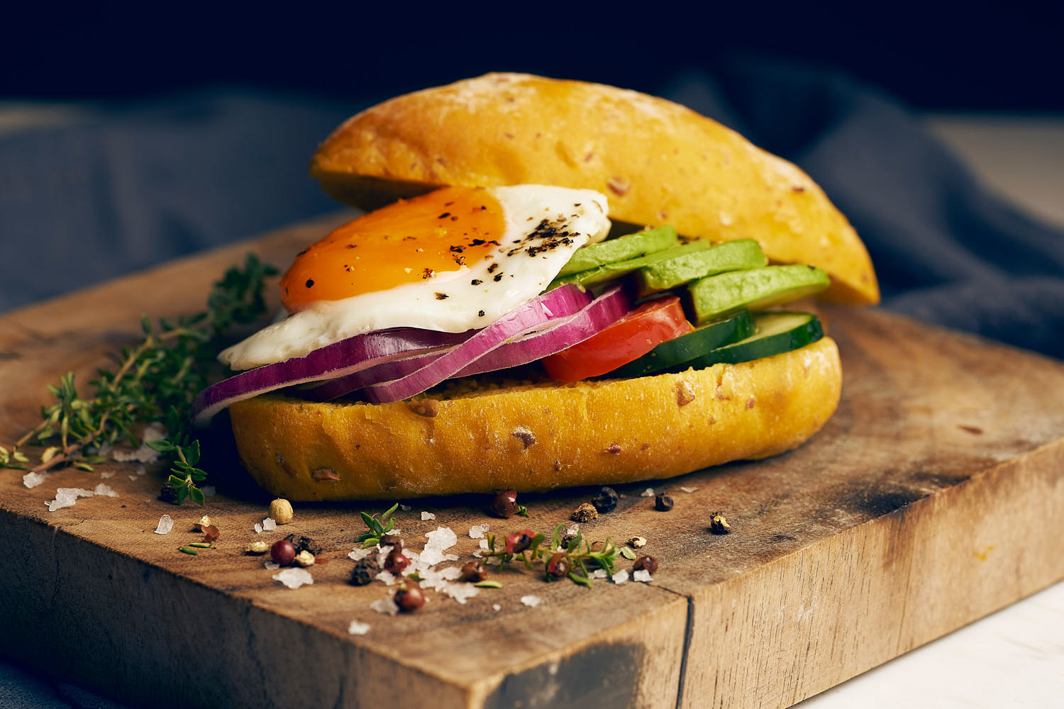 Rustic mood shot of a stacked sandwich with fresh ingredients on a wooden board.