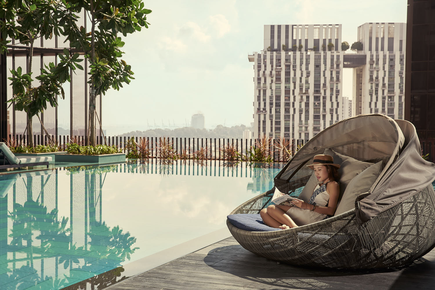 Guest relaxing solo by the poolside, soaking in the sun and tranquil atmosphere.