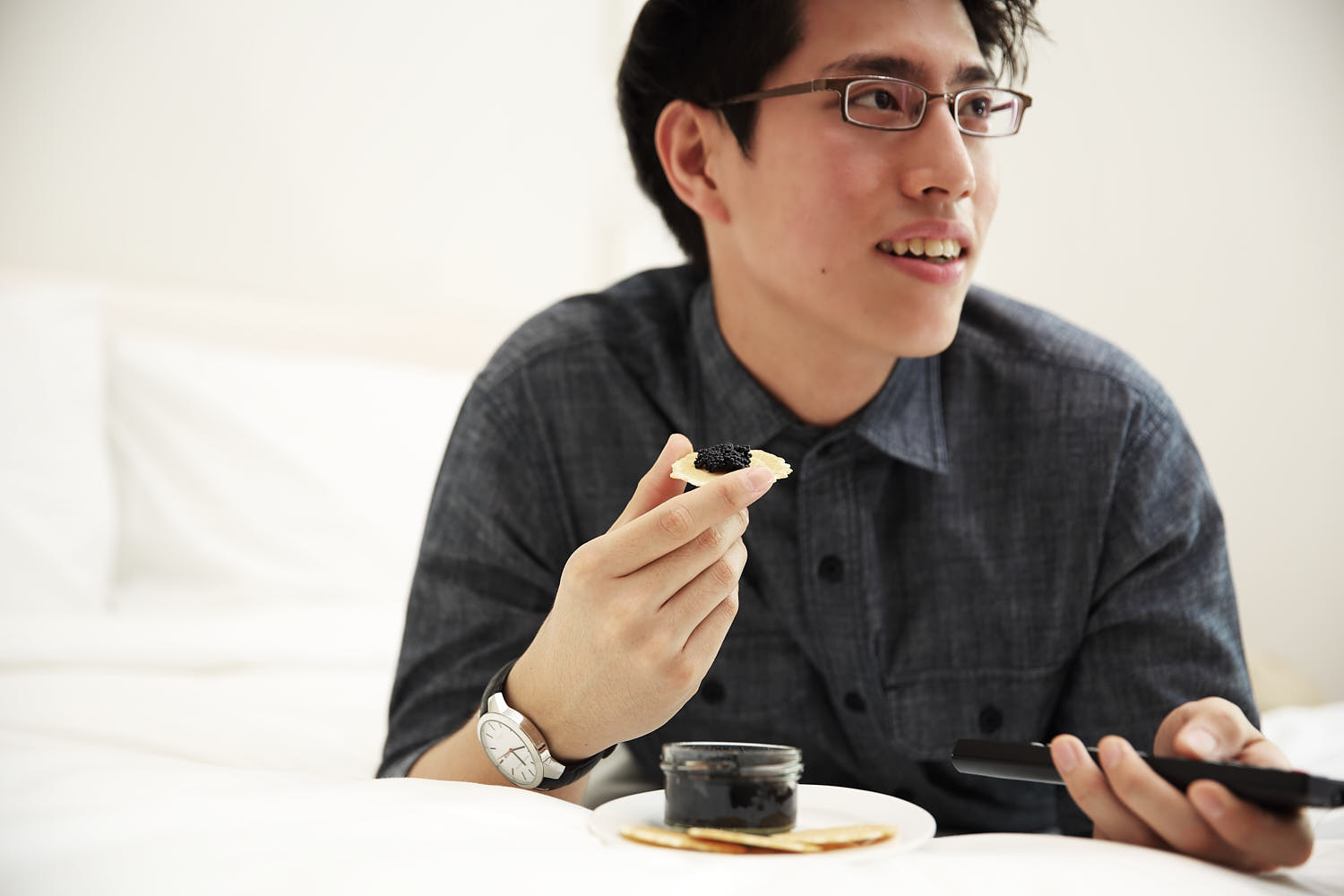 Guest indulging in gourmet caviar while relaxing in their stylish hotel room.