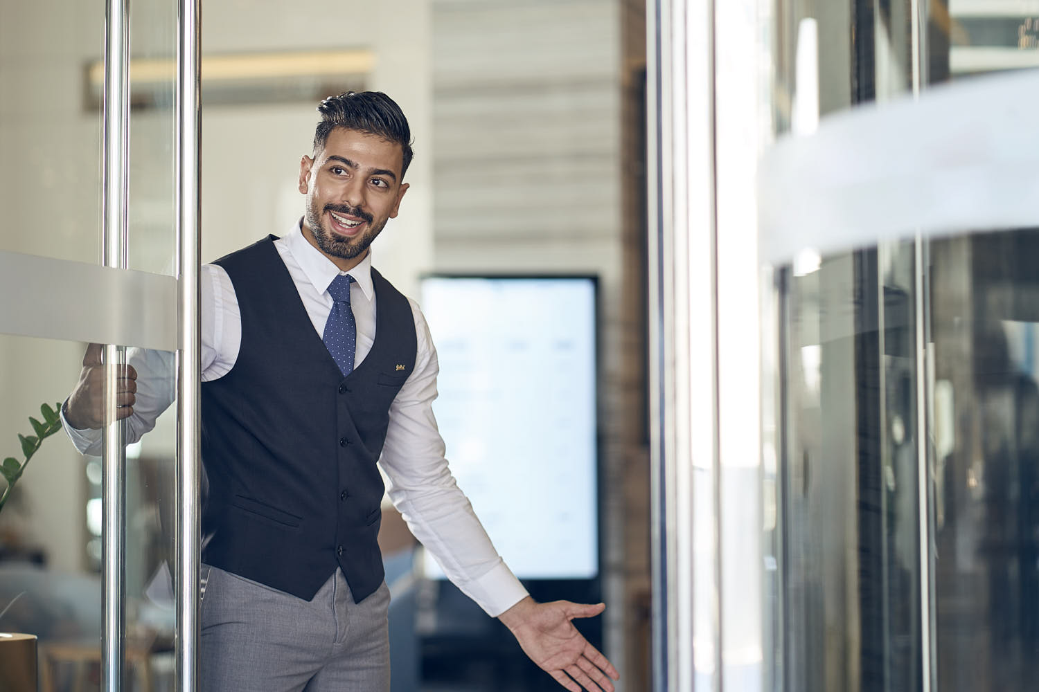 Friendly hotel staff at the entrance, smiling and ensuring a welcoming atmosphere for guests.