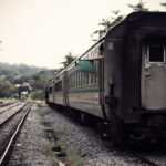 Fine art image of a stationary KTM train at Bukit Timah Railway Station, 1 Blackmore Drive, Singapore, with the train conductor peeking out of the resting train.
