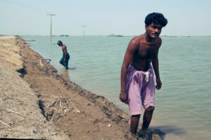 Two men packing soft soil near a levee to delay its collapse in Sujawal, Pakistan, August 2010.