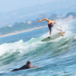 Surfer skillfully riding ocean waves at a beach in Bali, Indonesia.