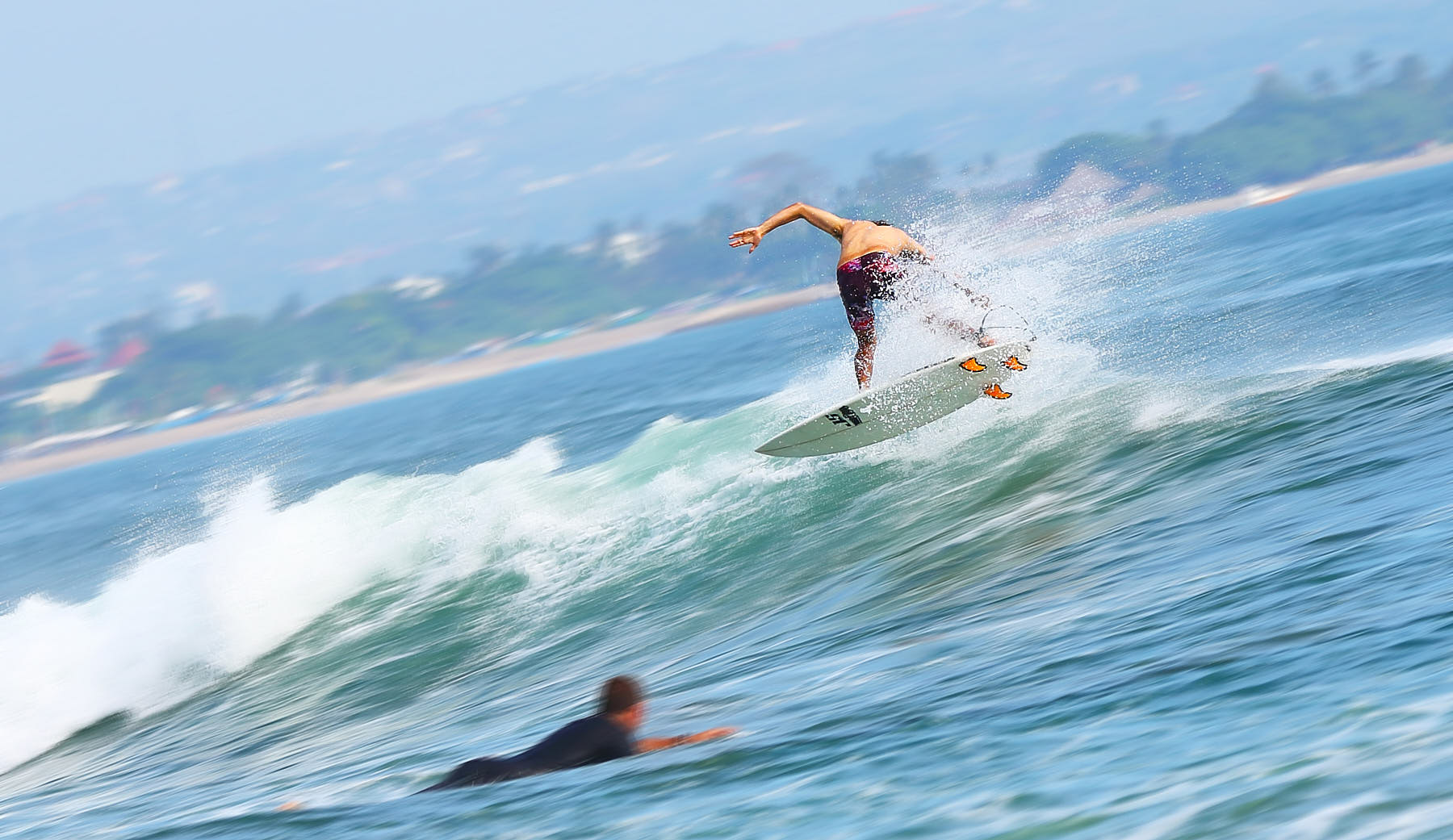 Surfer skillfully riding ocean waves at a beach in Bali, Indonesia.