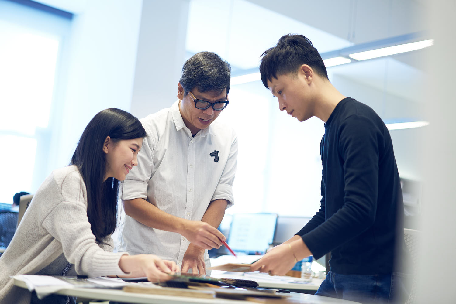 Group of professionals engaged in teamwork, discussing strategies and projects in an office.