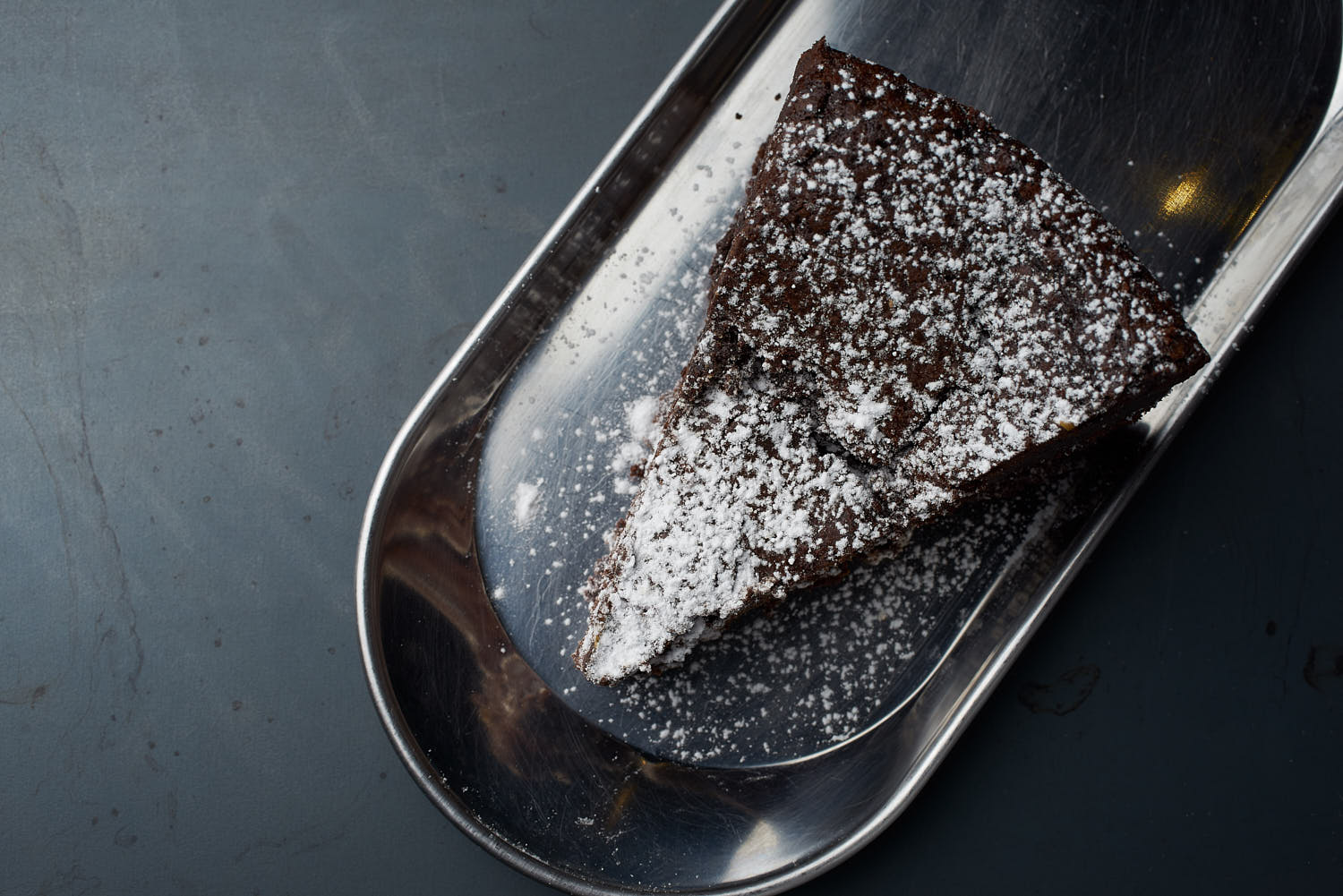 Top view of decadent chocolate cake featuring thick icing and a shiny finish.