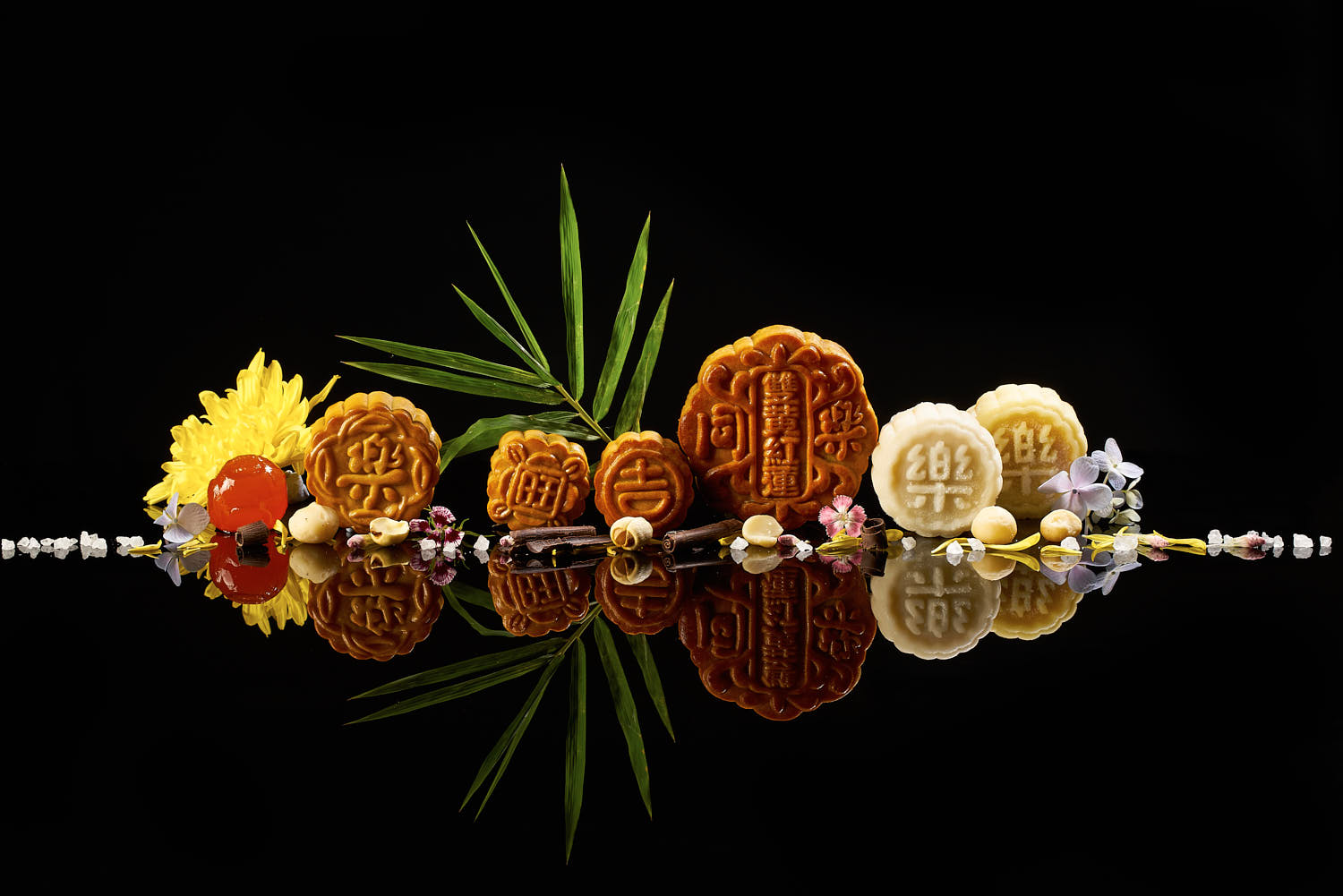 Straight row of TungLok mooncakes showcased on a sleek black reflective background.