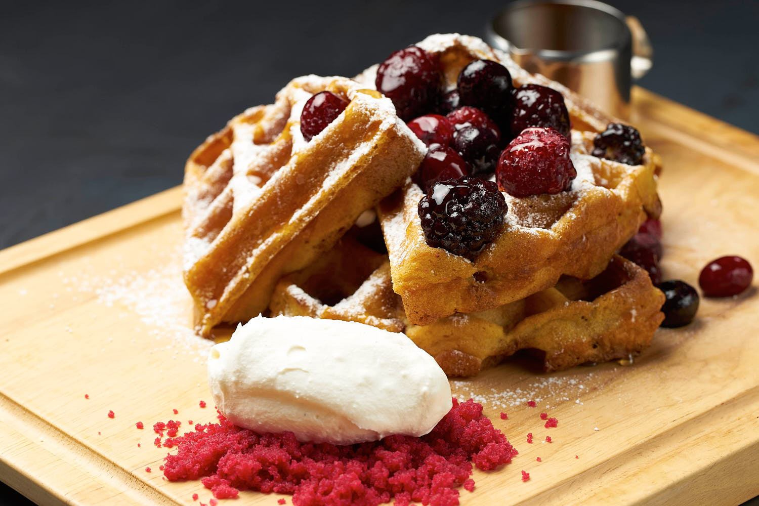 Golden waffles paired with strawberries, blueberries, and a scoop of creamy ice cream.