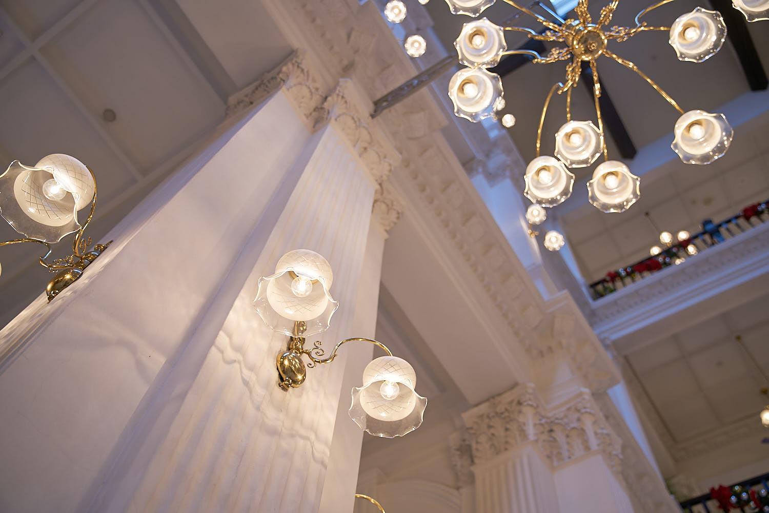 Close-up of vintage colonial lights at Raffles Hotel interior.